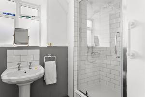 a white bathroom with a sink and a shower at Bellamarsh Farm B&B in Newton Abbot