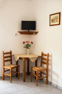 uma mesa com duas cadeiras e um vaso com flores em Panorama Plati em Plati