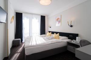 sypialnia z dużym łóżkiem i oknem w obiekcie Marena Wellness & Spa w mieście Międzywodzie
