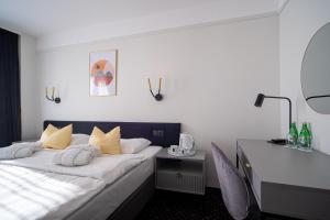 Pokój hotelowy z łóżkiem i biurkiem w obiekcie Marena Wellness & Spa w mieście Międzywodzie