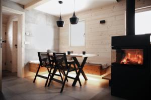 een eetkamer met een tafel en stoelen en een open haard bij Chalet Velika Planina-I FEEL ALPS in Stahovica