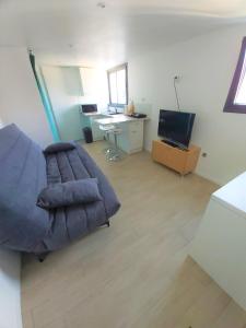 a living room with a couch and a desk at Bongraine Océan in La Rochelle