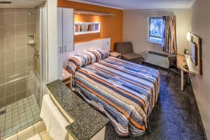 a hotel room with a bed and a shower at Road Lodge Germiston in Germiston