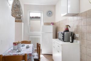 een kleine keuken met een tafel en een witte koelkast bij Ca' Mea in Diano San Pietro
