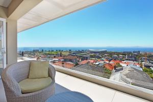 a balcony with a chair and a view of the city at Panova Luxury Suite by Totalstay in Cape Town
