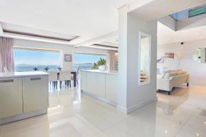 a white kitchen with a view of the ocean at Panova Luxury Suite by Totalstay in Cape Town