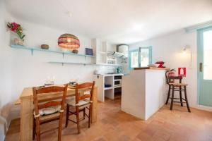 a kitchen and dining room with a table and chairs at Xaloc in Es Calo