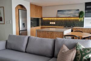 a living room with a couch and a kitchen at 25 Chaka's Cove in Ballito