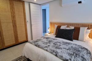 a bedroom with a large bed with a wooden headboard at 25 Chaka's Cove in Ballito