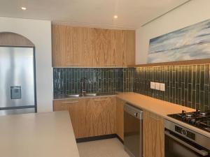 a kitchen with wooden cabinets and a sink and a stove at 25 Chaka's Cove in Ballito