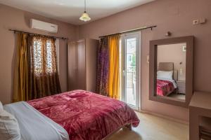 a bedroom with a bed and a mirror and a window at Fantastic Matala 1 in Matala