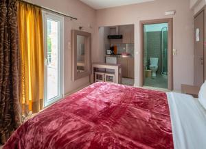 a bedroom with a large bed with a red blanket on it at Fantastic Matala 1 in Matala