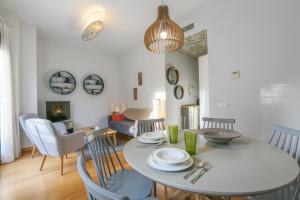 - une salle à manger et un salon avec une table et des chaises dans l'établissement Casa Piren, à Séville