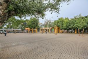 une grande place avec des arbres et des bâtiments dans un parc dans l'établissement Casa Piren, à Séville