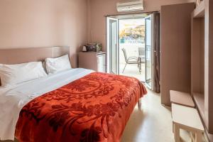 a bedroom with a bed with a red blanket at Fantastic Matala 1 in Matala