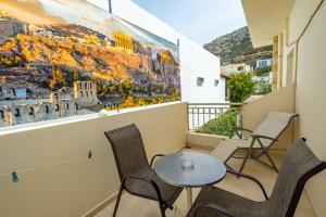 a balcony with a table and chairs and a painting on the wall at Fantastic Matala 1 in Matala