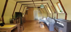 a living room with a couch and a tv at Ferienhaus am Helenesee 1 in Frankfurt Oder