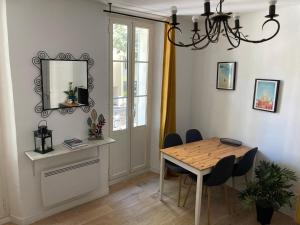 ein Esszimmer mit Tisch und Stühlen und einem Spiegel in der Unterkunft Grand T2 43m2 plages du Mourillon in Toulon