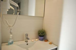 a white sink sitting under a window in a bathroom at Apartamentos Portodouro - Santa Catarina in Porto