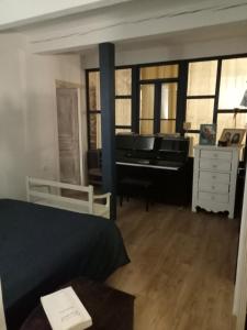 - une chambre avec un piano, un lit et un bureau dans l'établissement Maison de village 100m2, à Bédoin