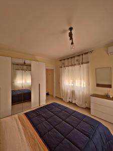 1 dormitorio con 1 cama grande y espejo en Casa Loredana en Putignano