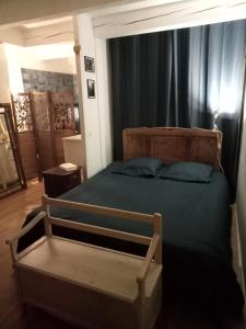 - une chambre avec un lit doté d'un cadre en bois dans l'établissement Maison de village 100m2, à Bédoin