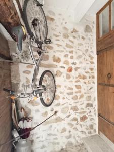 - un vélo suspendu sur un mur en pierre dans une pièce dans l'établissement Maison de village 100m2, à Bédoin