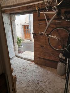 un vélo garé dans une pièce avec porte dans l'établissement Maison de village 100m2, à Bédoin