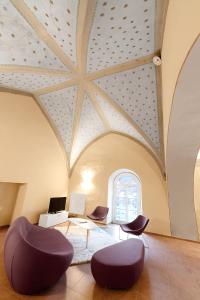 sala de estar con techo artesonado y sillas moradas en Ferienwohnungen im Kloster, en Gars am Kamp