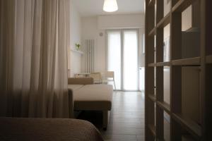 Zimmer mit einem Bett und einem Wohnzimmer in der Unterkunft Casa Aleardi grazioso e nuovissimo monolocale con balcone in Pesaro
