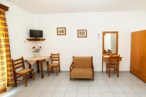 a room with a table and chairs and a television at Panorama Plati in Platy