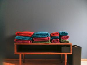 una pila de toallas coloridas sentadas en una mesa en Temari Inn Madoromi en Kurashiki