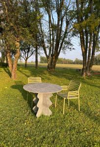 une table et deux chaises assises à côté d'un champ dans l'établissement Villa Leopardi, à Vignale