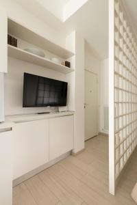 ein Wohnzimmer mit einem Flachbild-TV an einer weißen Wand in der Unterkunft Casa Aleardi grazioso e nuovissimo monolocale con balcone in Pesaro