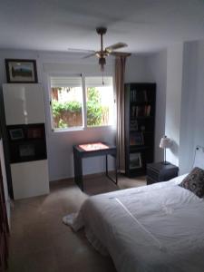 カサーレスにあるPlanta baja cerca de la playa Casares Costaのベッドルーム1室(ベッド1台、テーブル、窓付)