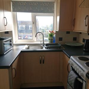 a kitchen with a sink and a window at Stylish 2 bed flat at Camber Sands in Camber