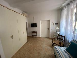 Habitación con cama, silla y TV. en Luisa Solferino 2 en Porto Azzurro