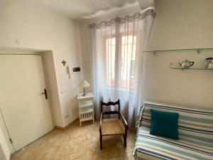 a bedroom with a bed and a chair and a window at Luisa Solferino 2 in Porto Azzurro