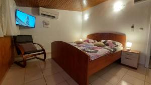 a bedroom with a bed and a chair and a tv at 3M Peristil in Split