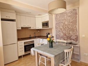 a kitchen with a table with a vase of flowers on it at Apartament Ca la Rosa in L'Ampolla