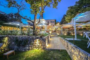 un patio con mesas y sombrillas por la noche en Les chambres d'hôtes de L'Oliveraie, en Opio