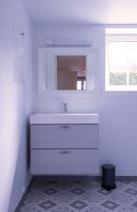 a white bathroom with a sink and a mirror at Studioleilighet i Sandnes sentrum in Sandnes