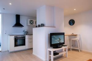 a living room with a tv on a white wall at Studioleilighet i Sandnes sentrum in Sandnes
