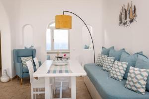 a living room with a couch and a table and chairs at Sensia villa with Hot tub and Caldera View in Oia