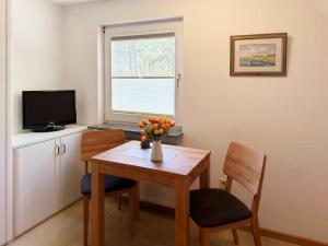 a dining room with a table and chairs and a television at Haus *Üüs Aran* Wohnung Nr. 3 in Nebel