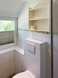 uma casa de banho com um WC e uma janela em Haus *Üüs Aran* Wohnung Nr. 3 em Nebel
