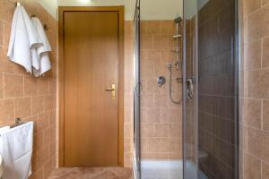 La salle de bains est pourvue d'une douche avec une porte en verre. dans l'établissement Casa Vacanza Baratz 4, à Alghero