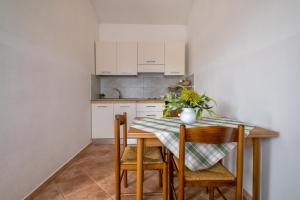 a kitchen with a table with two chairs and a tableablish at Casa Vacanza Baratz 4 in Alghero