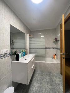 a white bathroom with a tub and a sink and a bath tub at Habitación privada in Valencia