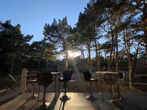 a table and chairs with the sun shining through the trees at Good Spot Morze in Rowy